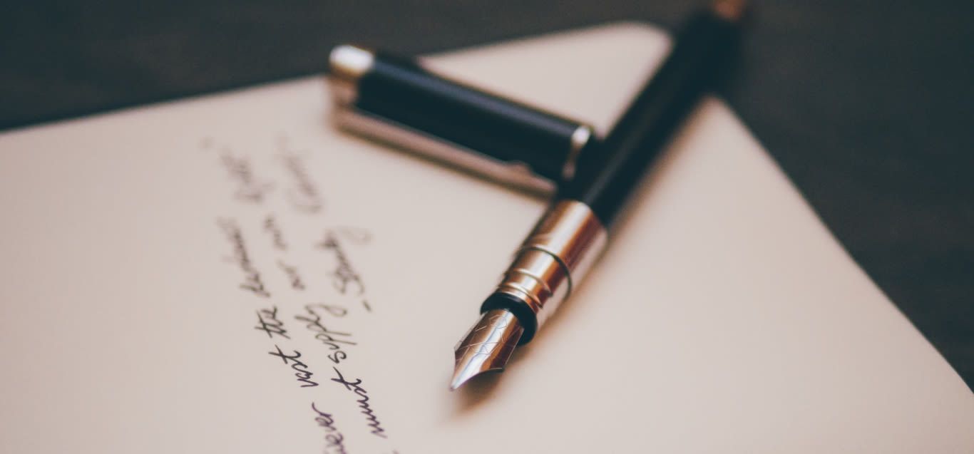 A fountain pen resting on a handwritten will