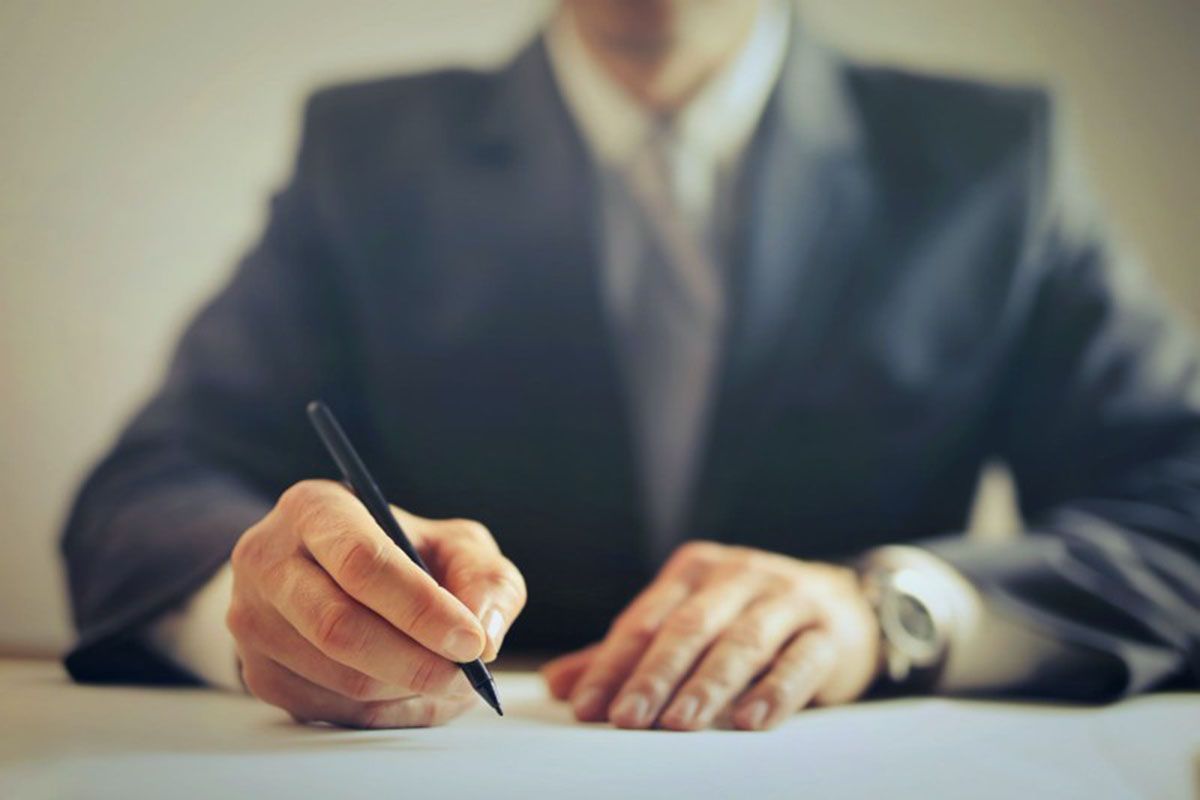 A person signing legal documents to settle an estate